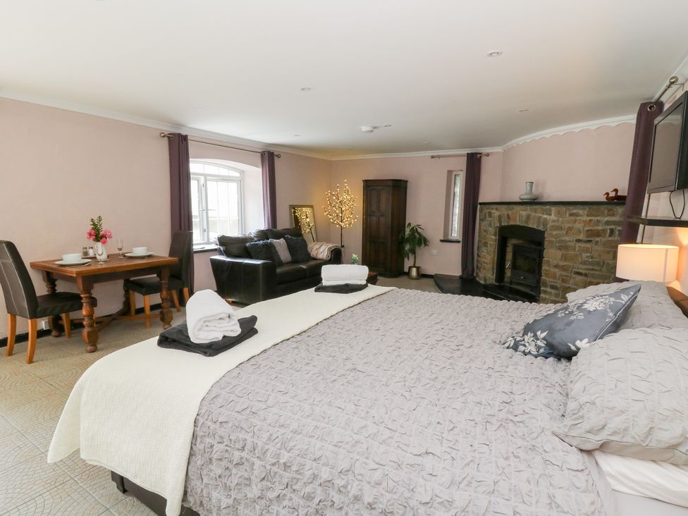 A bedroom with a dining table and seating area at Garden apartment in Llandysul