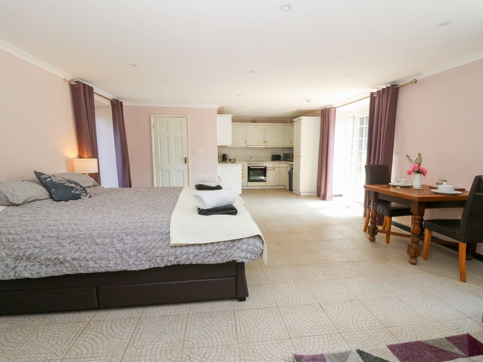 A studio with a bed and dining area at Garden apartment Llandysul