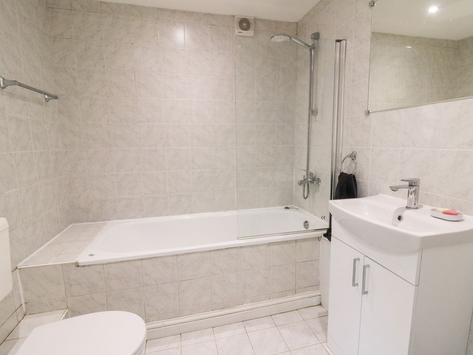 A bathroom with a bathtub and shower at Garden apartment in Llandysul