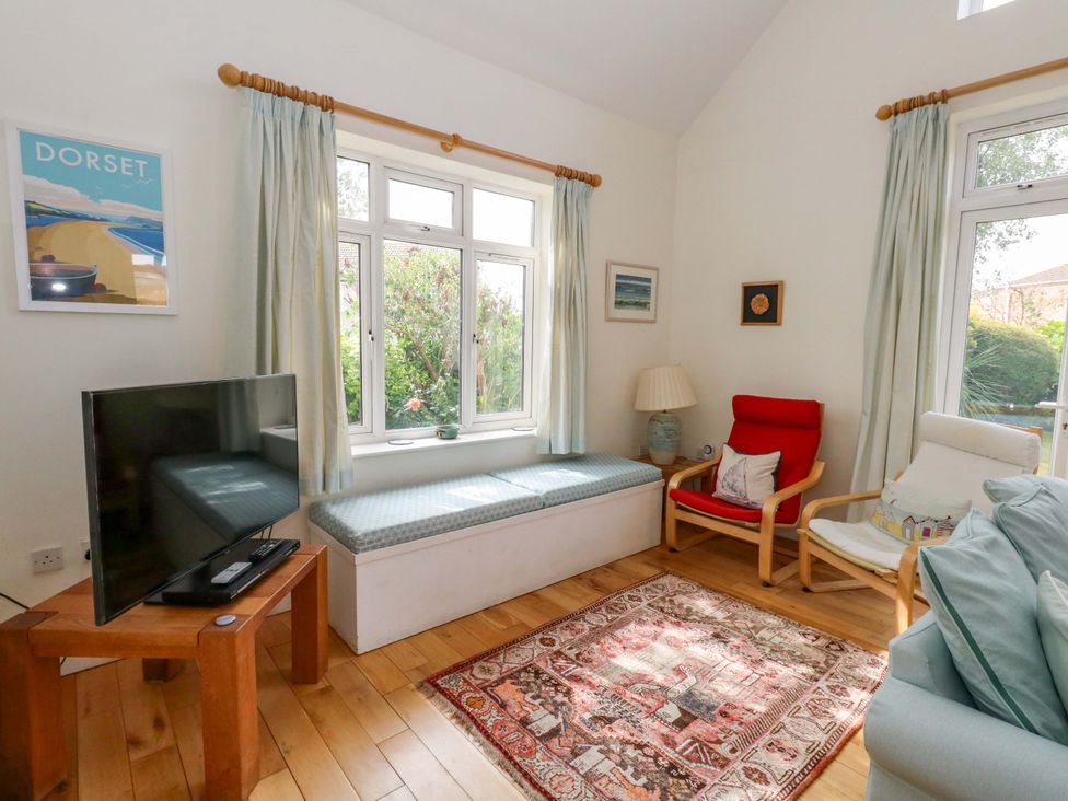 A living room with a television and seating area at 1 Fernhill Avenue Weymouth