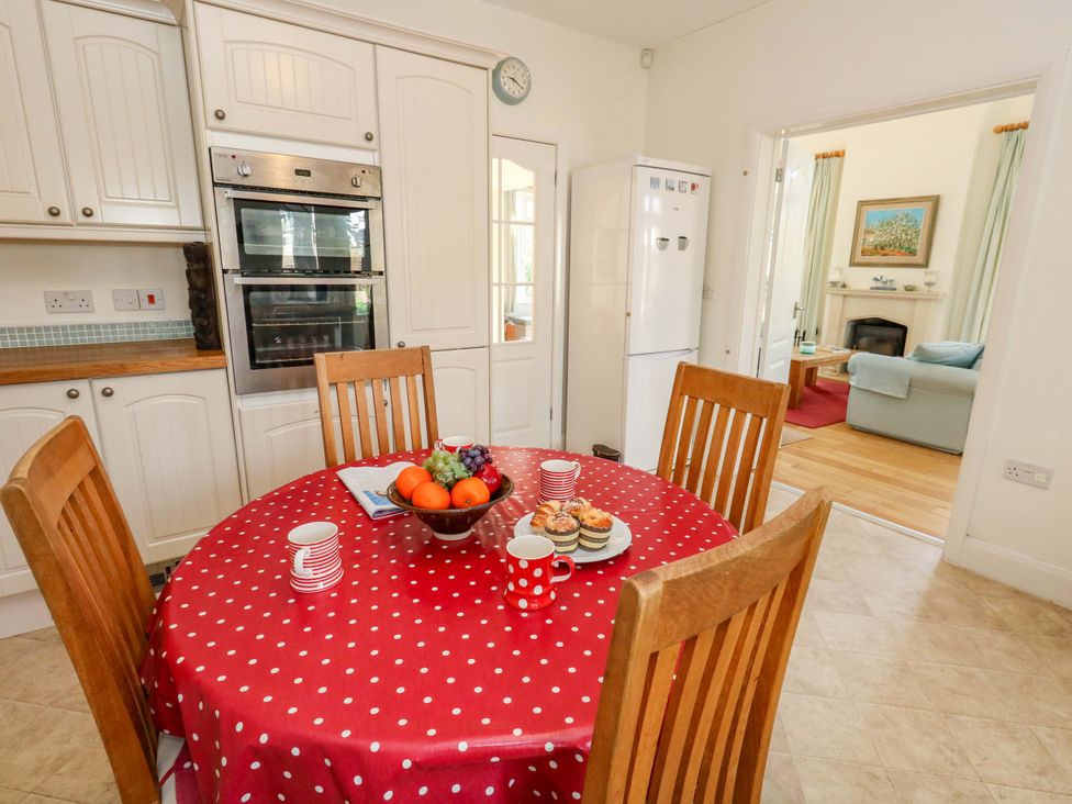 A kitchen with a dining table and chairs at 1 Fernhill Avenue Weymouth