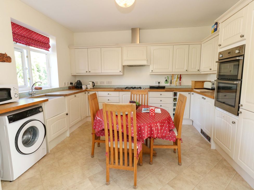 A kitchen with a table and chairs at 1 Fernhill Avenue Weymouth