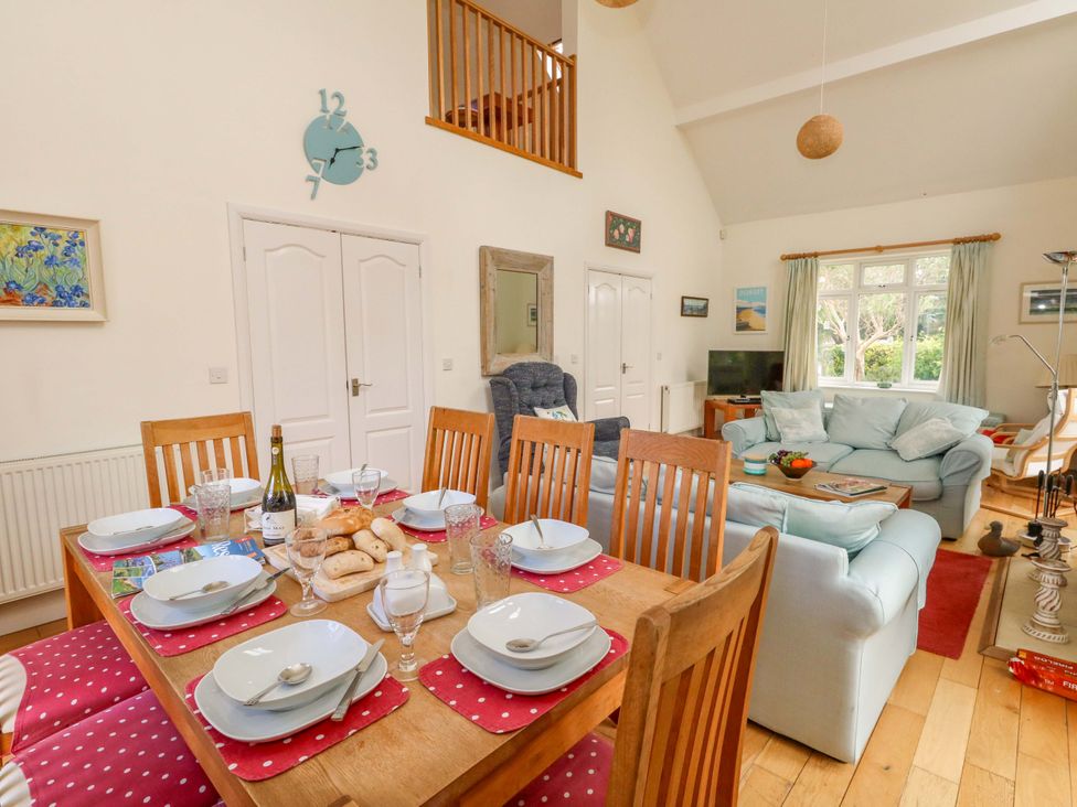 A kitchen and dining area with a table set for meal at 1 Fernhill Avenue in Weymouth