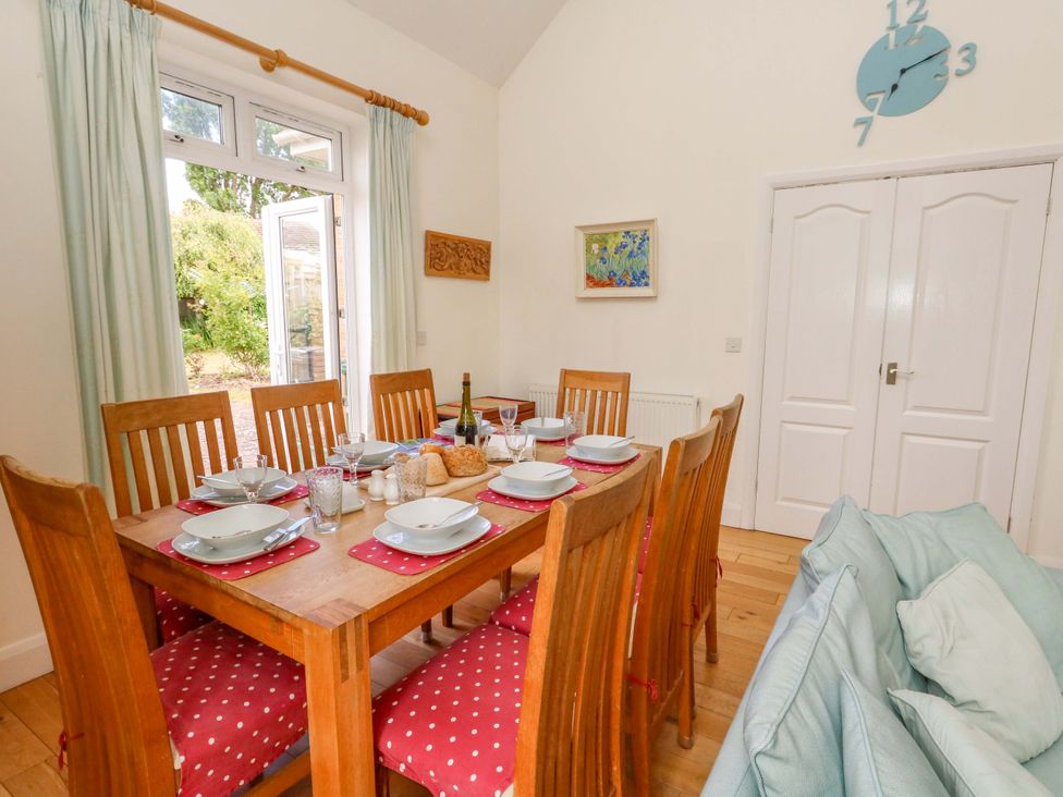 A dining room with a table and chairs at 1 Fernhill Avenue Weymouth