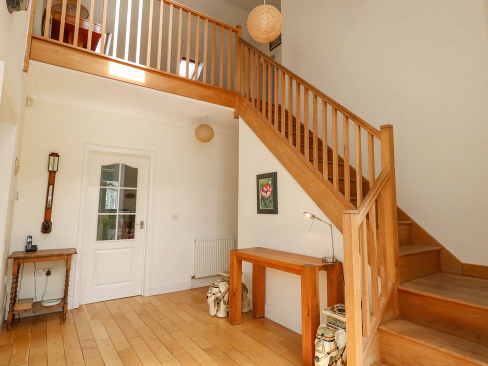 A hallway featuring a staircase and table at 1 Fernhill Avenue Weymouth