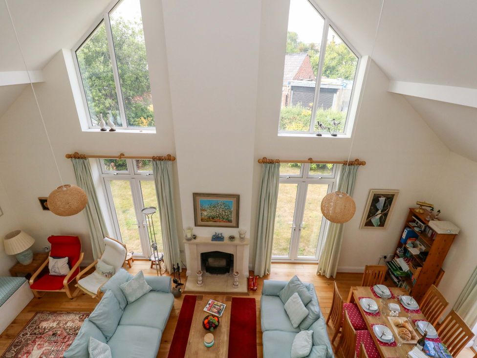 A living room with a sofa and dining area at 1 Fernhill Avenue Weymouth
