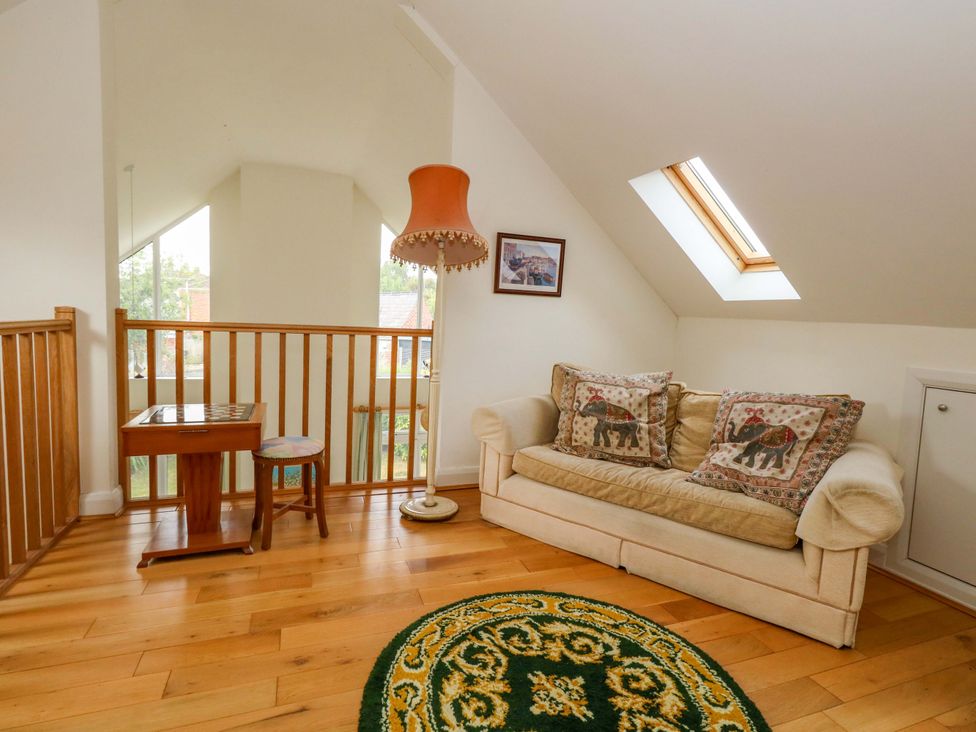 A living room with a sofa and a lamp at 1 Fernhill Avenue Weymouth