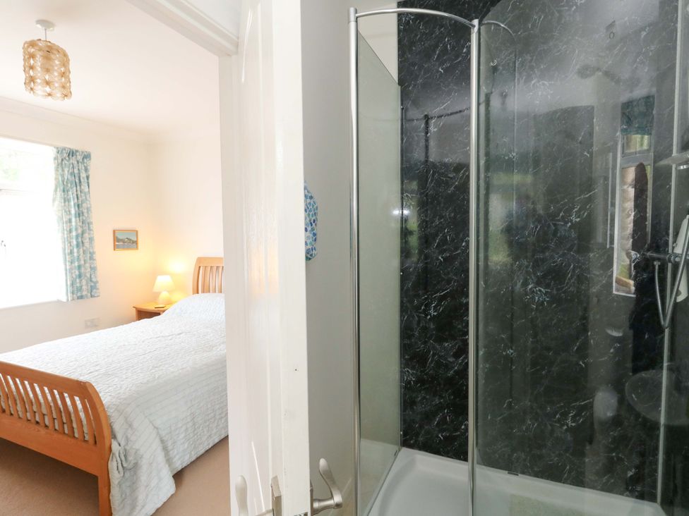 A bedroom with a bed and shower visible at 1 Fernhill Avenue Weymouth