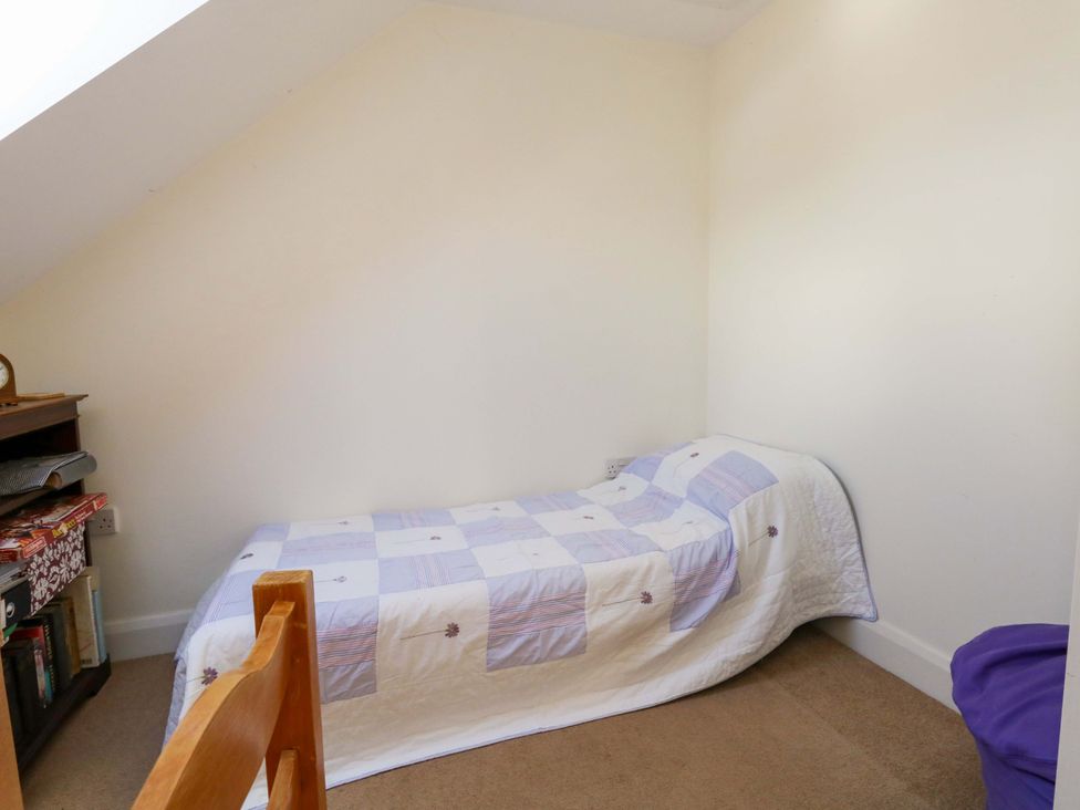 A bedroom with a single bed and shelf at 1 Fernhill Avenue Weymouth