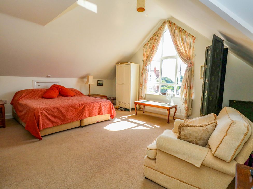 A bedroom with a bed and sofa at 1 Fernhill Avenue, Weymouth