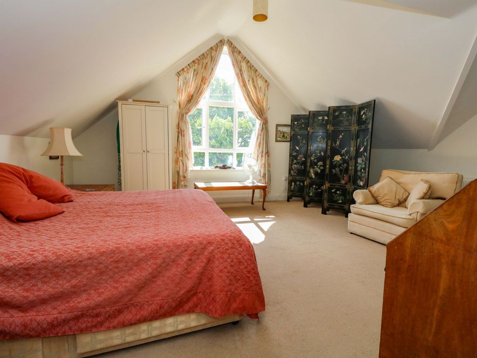 A bedroom with a bed, wardrobe, and window at 1 Fernhill Avenue Weymouth