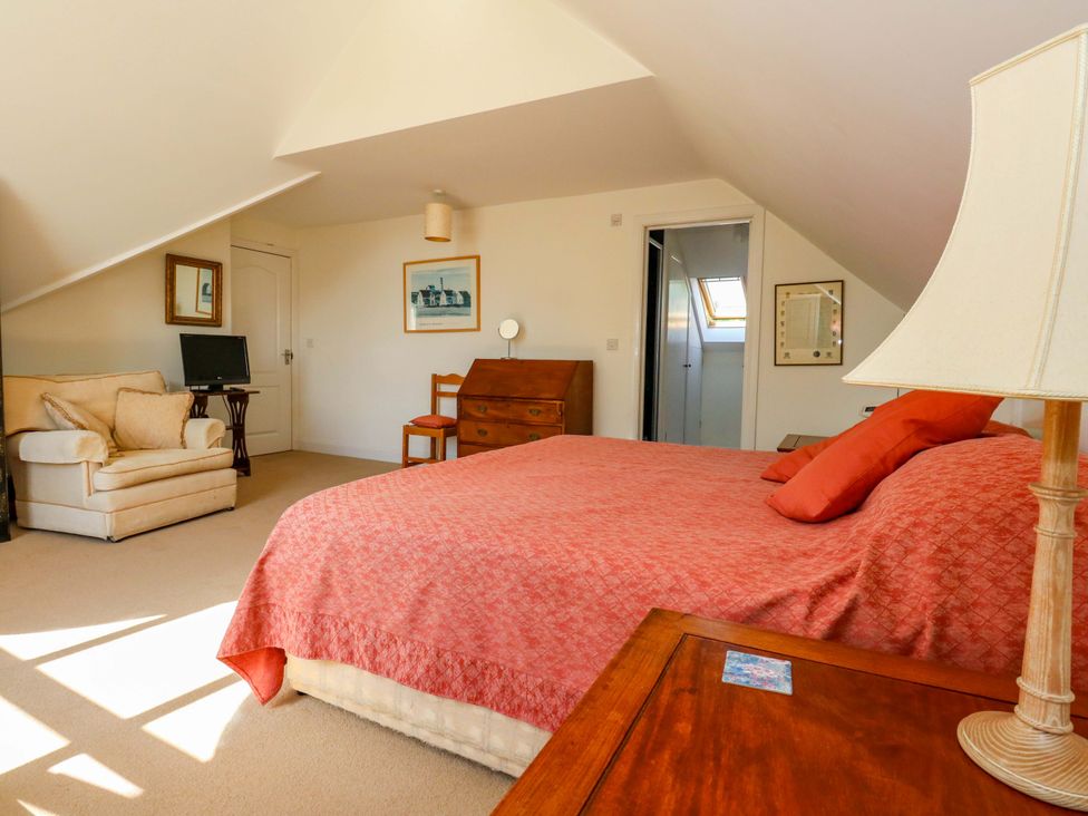 A bedroom with a bed and a desk at 1 Fernhill Avenue in Weymouth