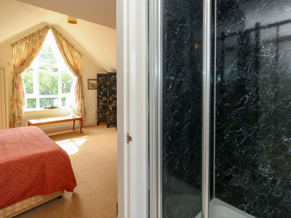 A bedroom with a bed and a shower visible at 1 Fernhill Avenue Weymouth