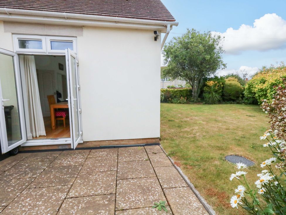 A garden view from a patio with doors open at 1 Fernhill Avenue Weymouth