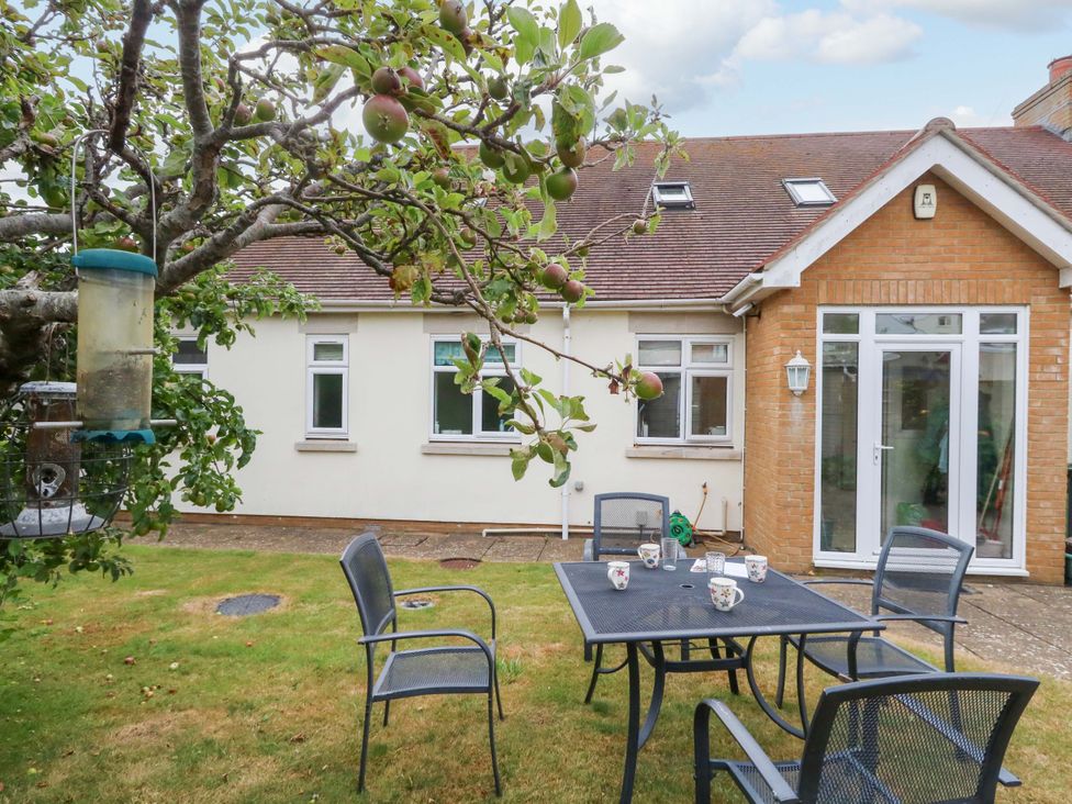 A garden with a table and chairs near a tree at 1 Fernhill Avenue Weymouth