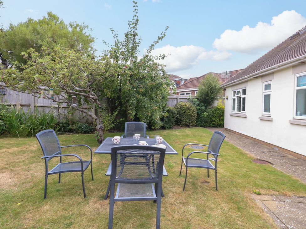 A garden with a table and chairs at 1 Fernhill Avenue Weymouth