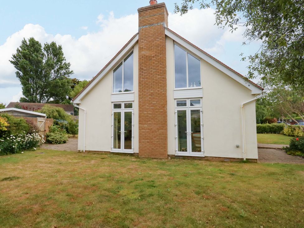 A house exterior with a chimney and large windows at 1 Fernhill Avenue in Weymouth