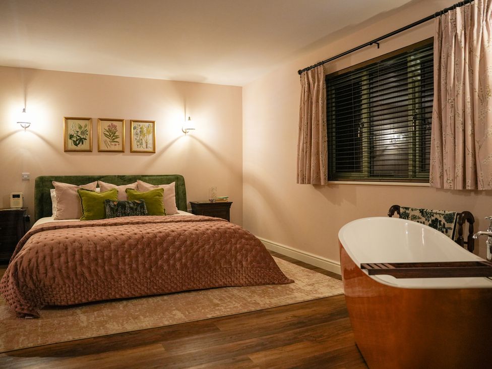A bedroom with a bed and a bathtub at Ystrad Wen in Llysdinam near Newbridge-On-Wye