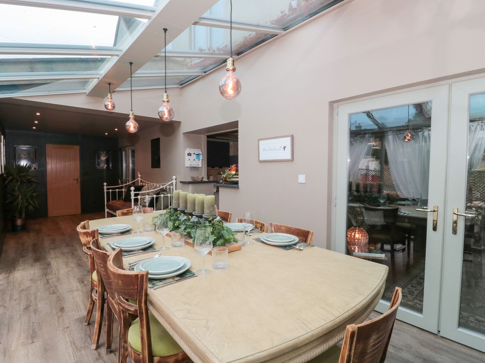 A dining room with a table set for meals at Yarn Cottage in Broadway