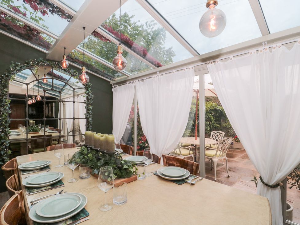 A dining room with a table set for a meal at Yarn Cottage in Broadway