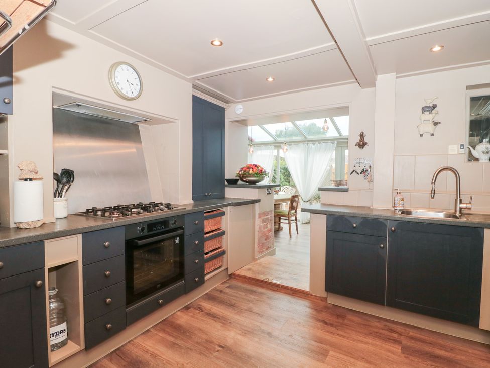 A kitchen with a stove, oven, and sink at Yarn Cottage in Broadway