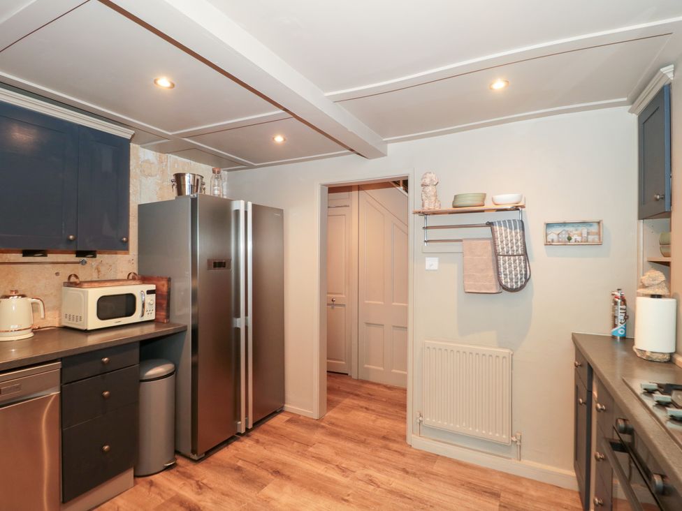 A kitchen with appliances and cabinets at Yarn Cottage in Broadway