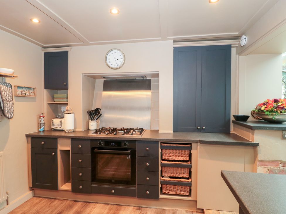 A kitchen with cabinets and an oven at Yarn Cottage in Broadway