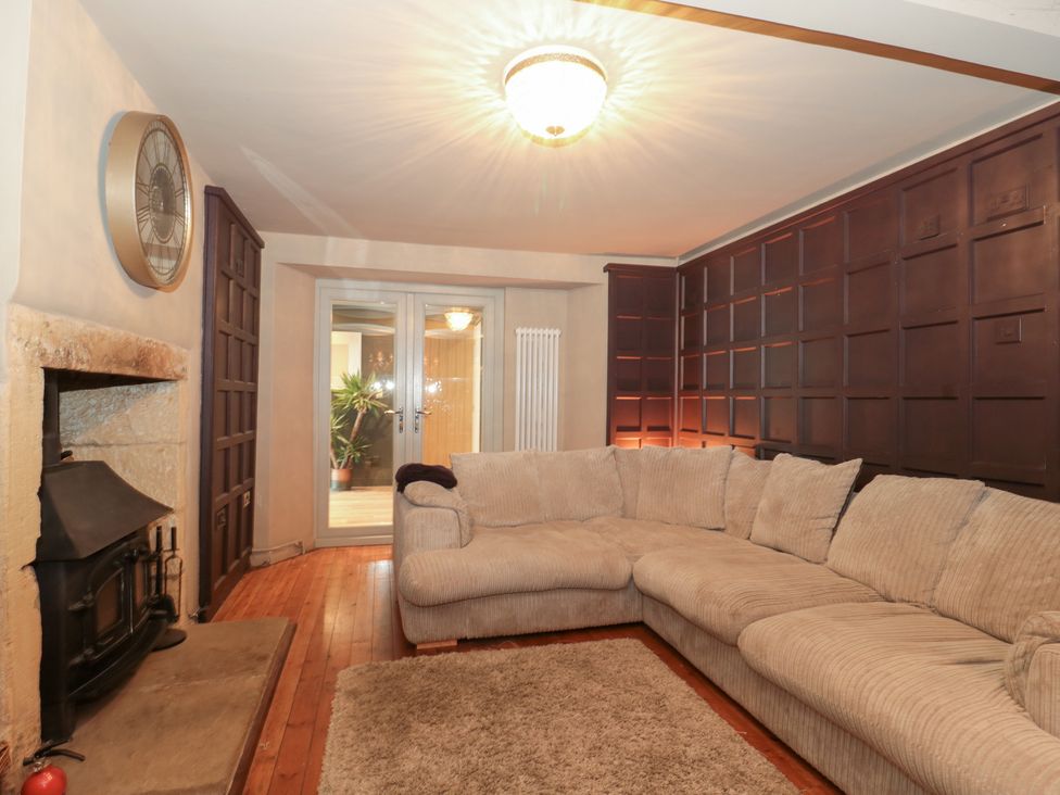 A living room with a sofa and fireplace at Yarn Cottage in Broadway