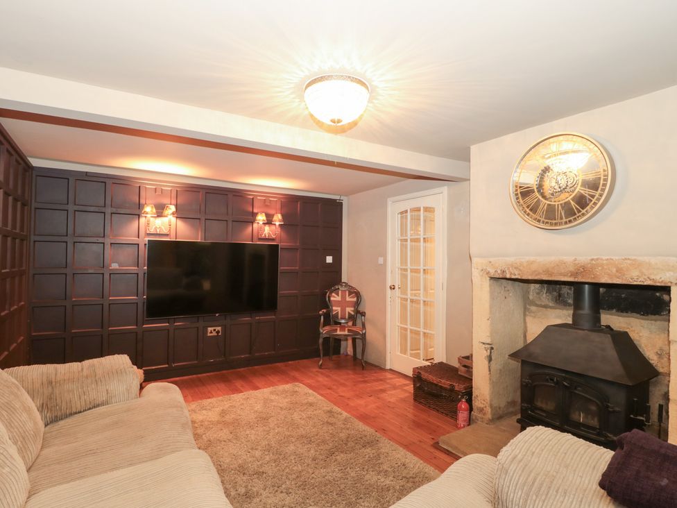 A living room with a television and fireplace at Yarn Cottage in Broadway