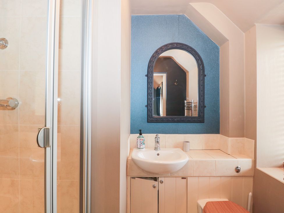 A bathroom featuring a shower, sink, and toilet at Yarn Cottage in Broadway