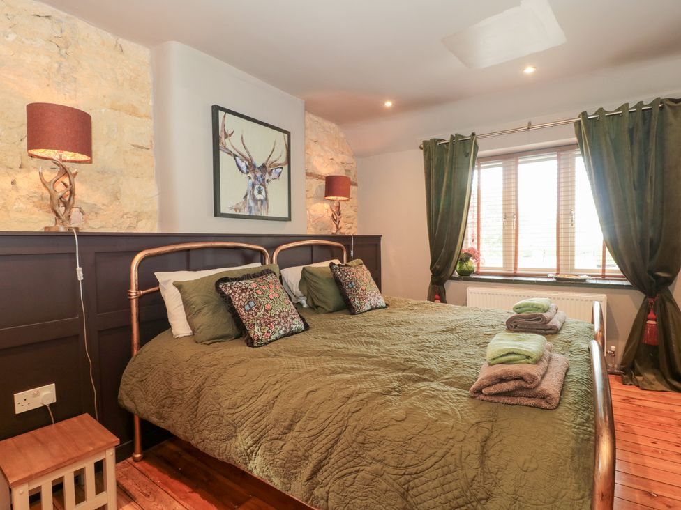 A bedroom with a bed and bedding at Yarn Cottage in Broadway