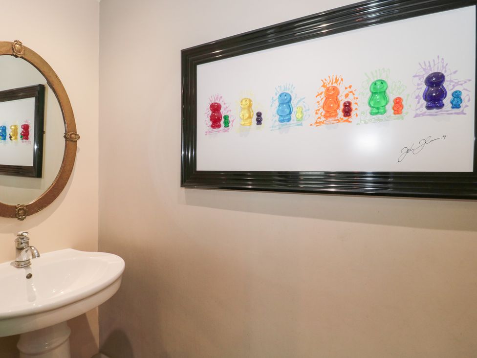 A bathroom with a mirror and a sink at Yarn Cottage in Broadway