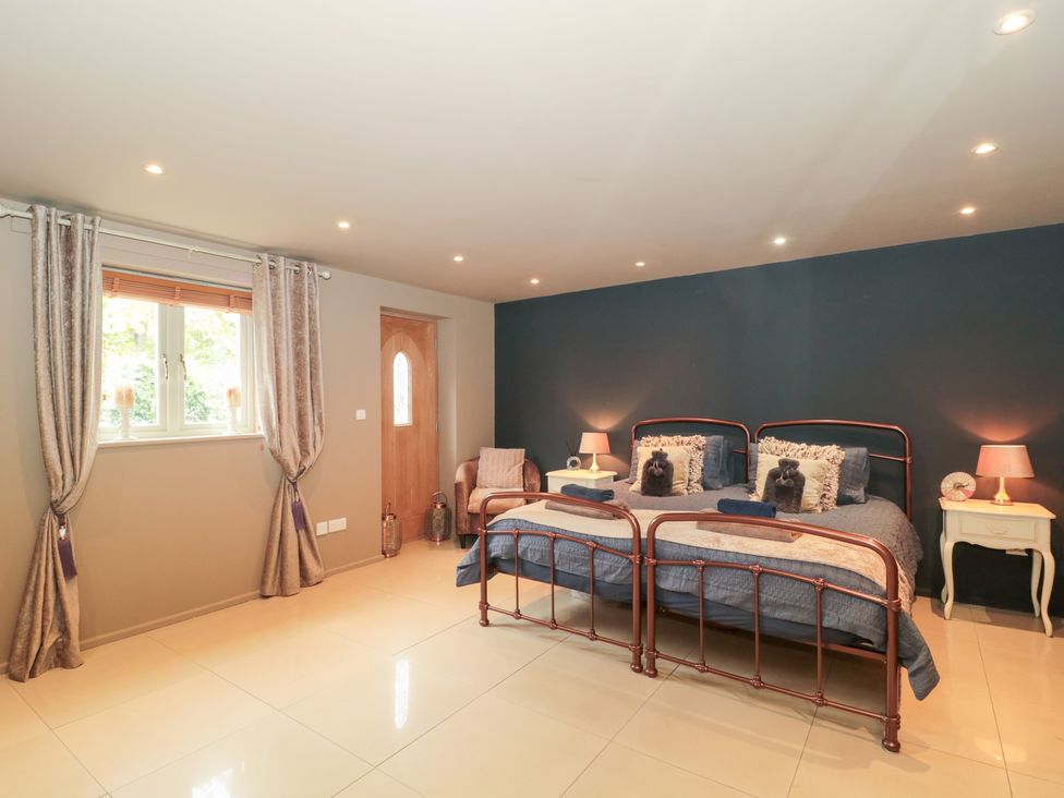 A bedroom with a bed and side table at Yarn Cottage Broadway