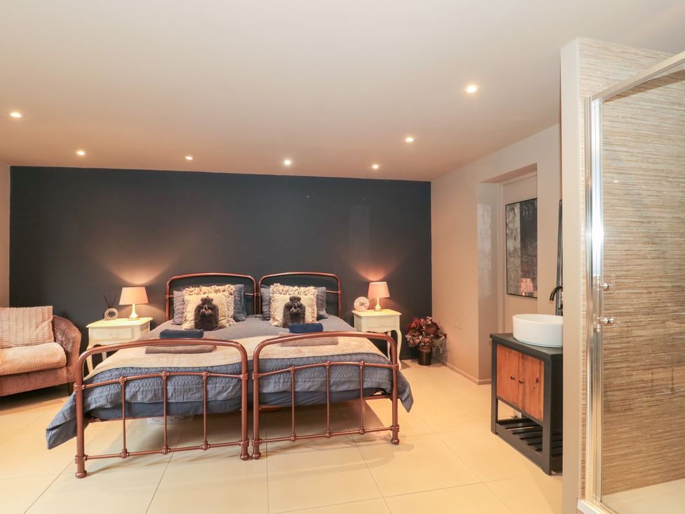A bedroom with a bed and nightstands at Yarn Cottage in Broadway