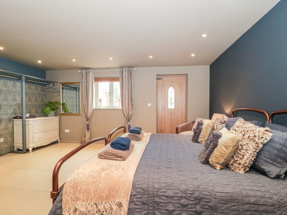 A bedroom with a bed and dresser at Yarn Cottage in Broadway