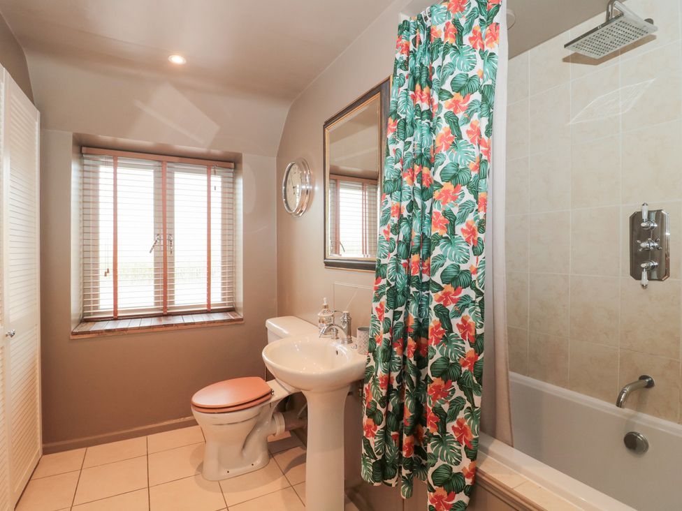 A bathroom with a sink and bathtub at Yarn Cottage in Broadway