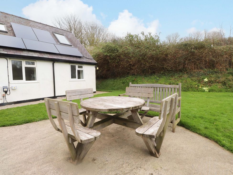 A table and benches on a patio at Belan Wen in Llanddona near Pentraeth