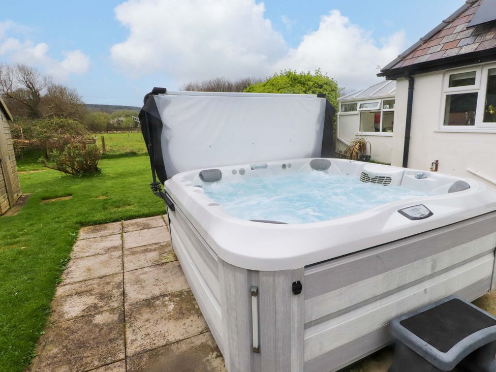 A hot tub on a patio in the garden at Belan Wen in Llanddona near Pentraeth