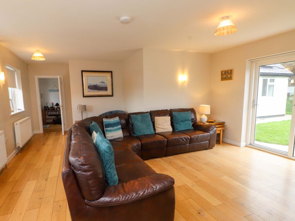 A living room with a sofa and lamp at Belan Wen in Llanddona near Pentraeth