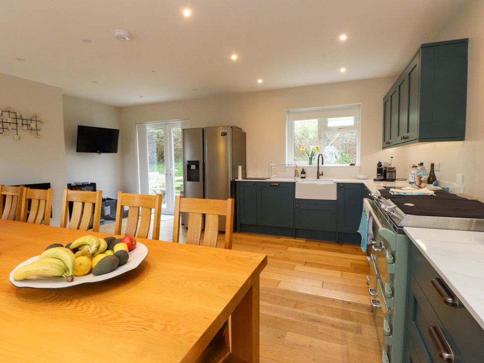 A kitchen with a table and fruit bowl at Belan Wen in Llanddona near Pentraeth