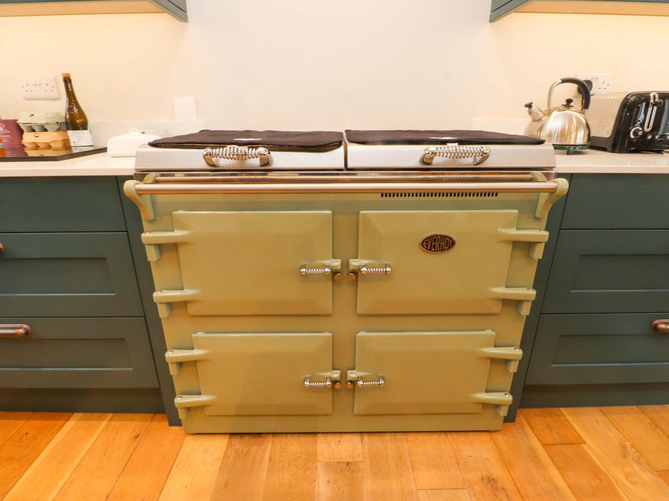 A stove with kitchen cabinets and countertop at Belan Wen in Llanddona near Pentraeth
