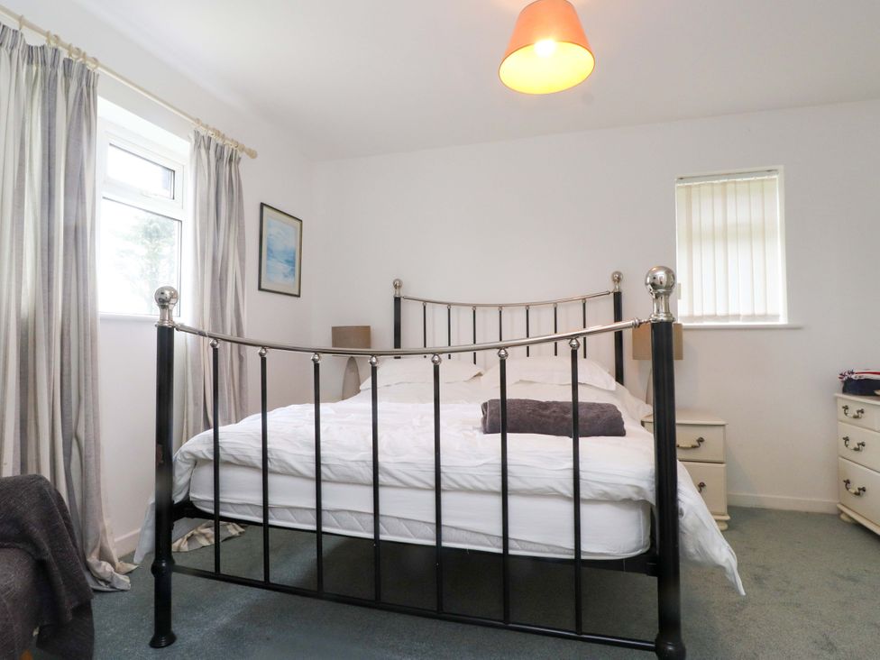 A bedroom with a bed and bedside table at Belan Wen Llanddona near Pentraeth