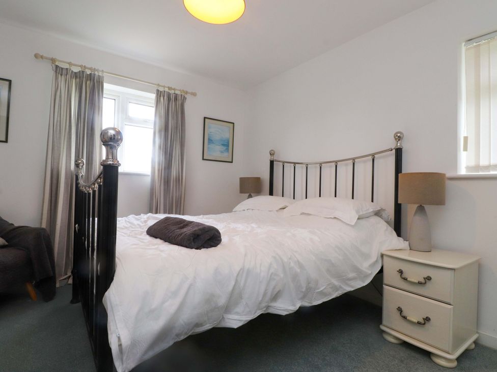 A bedroom with a bed and bedside tables with lamps at Belan Wen Llanddona near Pentraeth