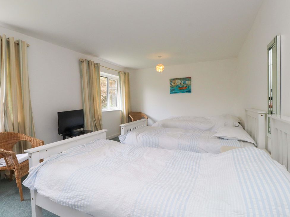 A bedroom with two beds and a television at Belan Wen in Llanddona near Pentraeth