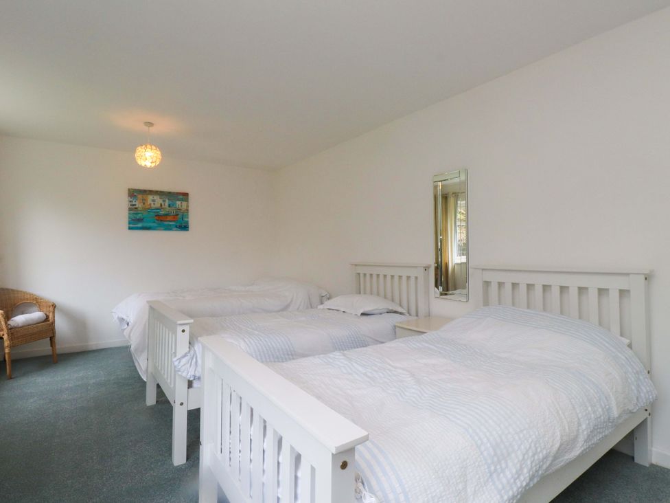 A bedroom with two beds and a mirror at Belan Wen Llanddona near Pentraeth