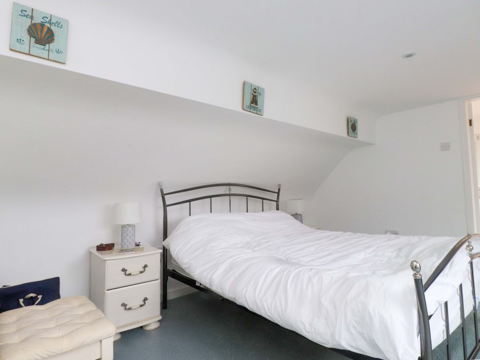 A bedroom with a bed and nightstand at Belan Wen in Llanddona near Pentraeth