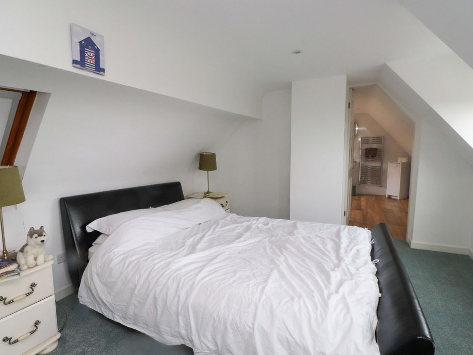 A bedroom with a bed and nightstand at Belan Wen in Llanddona near Pentraeth