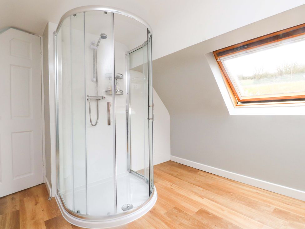 A bathroom with a shower enclosure and window at Belan Wen in Llanddona near Pentraeth