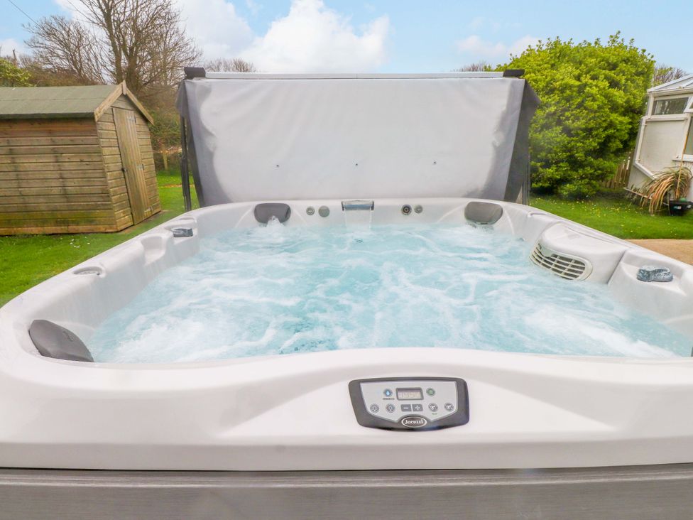 A hot tub with water and control panel in the outdoor area at Belan Wen in Llanddona near Pentraeth
