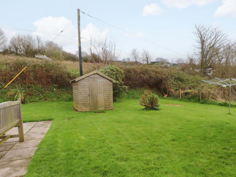 A garden with a shed and clothesline at Belan Wen in Llanddona near Pentraeth